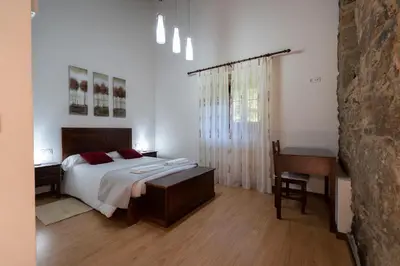 a bedroom with a bed and a table and a desk at Casa rural completa Río Sarela in Santiago de Compostela