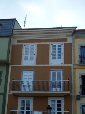a brown building with white windows and a balcony at SAN FRANCISCO in Ribadeo