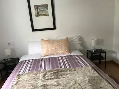 a bedroom with a bed with two end tables at Polvorín in Ourense