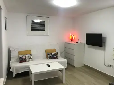 a living room with a white couch and a tv at Polvorín in Ourense