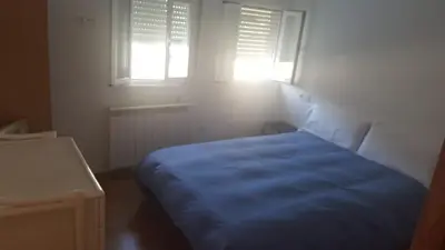 a bedroom with a blue bed and two windows at Polvorín in Ourense