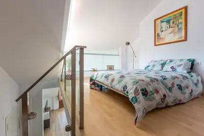 a white bedroom with a bed and a staircase at Apartamentos Moreira & Betanzos in Betanzos