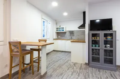 a kitchen with a wooden table and a refrigerator at Apartamentos Moreira & Betanzos in Betanzos
