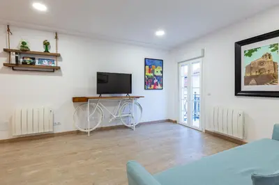 a living room with a tv and a bike on the wall at Apartamentos Moreira & Betanzos in Betanzos