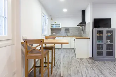 a kitchen with a wooden table and a refrigerator at Apartamentos Moreira & Betanzos in Betanzos