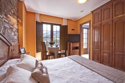a bedroom with a large bed and a table at Hotel Rural Casa Paulino in Taramundi