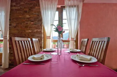 a pink table with plates and a vase of flowers on it at Hotel Rural Casa Paulino in Taramundi