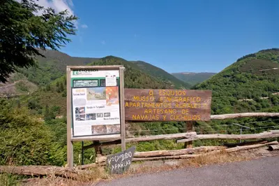 a sign on the side of a road with mountains in the background at Hotel Rural Casa Paulino in Taramundi