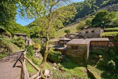 a village on a hill with a wooden fence at Hotel Rural Casa Paulino in Taramundi