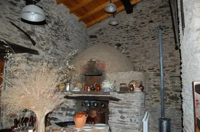 a kitchen with a stone wall with a stove at Pacio do Sil in La Rúa