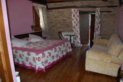 a bedroom with a bed and a chair at Pacio do Sil in La Rúa