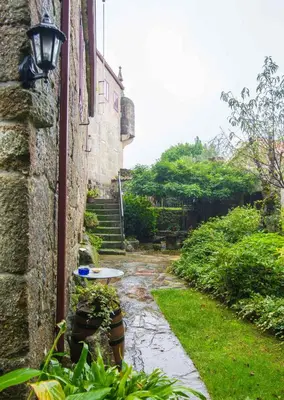 a stone building with a table in a yard at Pazo Da Fraga in Albeos
