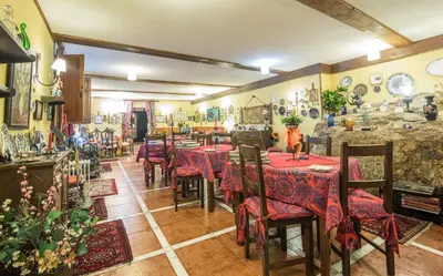 a restaurant with tables and chairs in a room at Pazo Da Fraga in Albeos