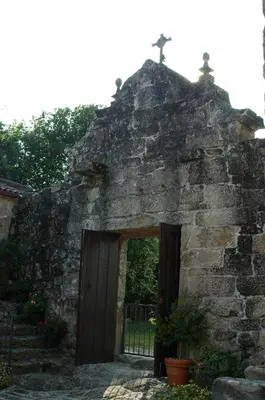 an entrance to an old stone building with a cross on top at Pazo Da Fraga in Albeos