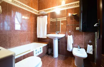 a bathroom with a sink and a tub and a toilet at Pazo Da Fraga in Albeos