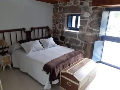 a bedroom with a bed and a stone wall at Vila Morena in Corzos