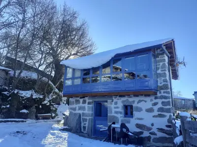 a house with a blue window on top of it at Vila Morena in Corzos