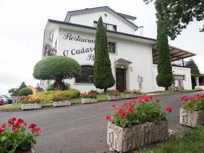a white building with flowers in front of it at Hostal Restaurante O'Cadaval in Frades
