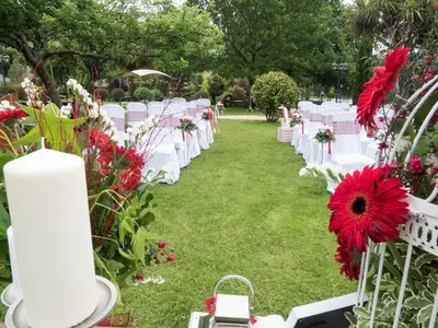 an aisle with white chairs and red flowers at Hostal Restaurante O'Cadaval in Frades