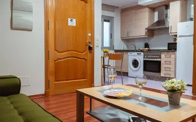 a kitchen with a table with two glasses of wine at A Casa Antiga do Monte Apartamentos Turísticos - Pontecesures in Padrón