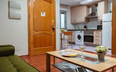a kitchen with a table and two glasses of wine at A Casa Antiga do Monte Apartamentos Turísticos - Pontecesures in Padrón