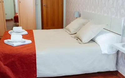 a white bed with two towels on top of it at A Casa Antiga do Monte Apartamentos Turísticos - Pontecesures in Padrón