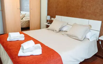 a bedroom with a white bed with towels on it at A Casa Antiga do Monte Apartamentos Turísticos - Pontecesures in Padrón