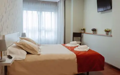 a bedroom with a large bed with two towels on it at A Casa Antiga do Monte Apartamentos Turísticos - Pontecesures in Padrón