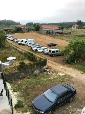 a row of cars parked in a parking lot at Pensión Tasaga in O Pino