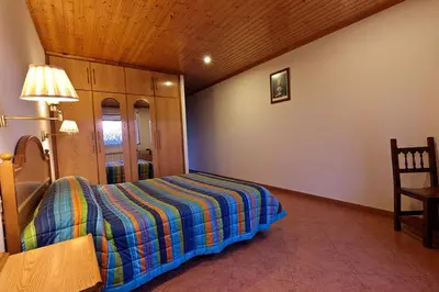 a bedroom with a bed and a table and a lamp at Casa Cazoleiro in Meira