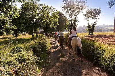 a group of people riding horses down a dirt road at Casa Cazoleiro in Meira