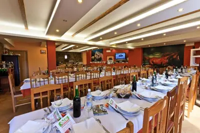 a dining room with a long table with bottles of wine at Casa Cazoleiro in Meira