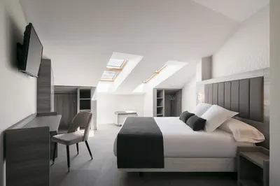 a bedroom with a bed and a desk and a chair at Hostal Pórtico in Betanzos