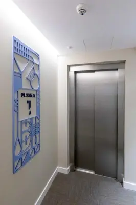 a hallway with a door with a sign on the wall at Hostal Pórtico in Betanzos