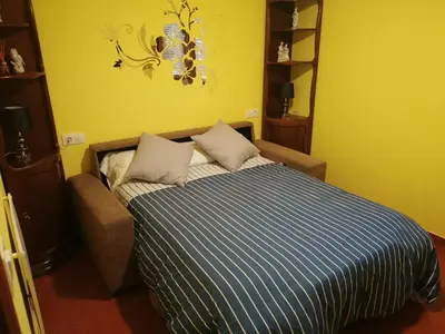 a bed in a room with a yellow wall at CASA SEGADE in A Coruña