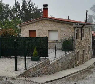 a brick house with a fence in front of it at CASA SEGADE in A Coruña