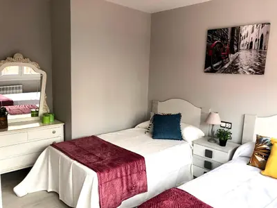 a bedroom with two beds and a mirror at Apartamento Adelina in Silleda