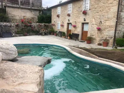 a swimming pool in front of a building at Casa Cabaleira in Silleda