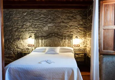 a bedroom with a bed with a wall with trees at Casa de Costoia in Santiago de Compostela