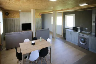 a living room with a table and chairs and a washing machine at CELTAINER in Maceda