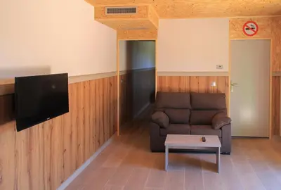 a living room with a couch and a flat screen tv at CELTAINER in Maceda