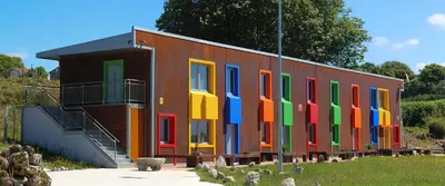 a building with colorful doors on the side of it at CELTAINER in Maceda