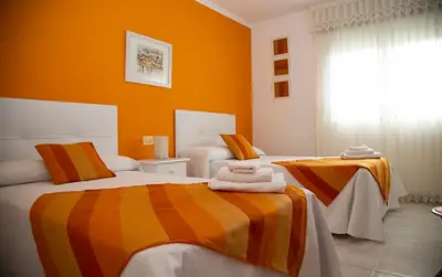 two beds in a room with orange walls at Pico da Costa in Barreiros