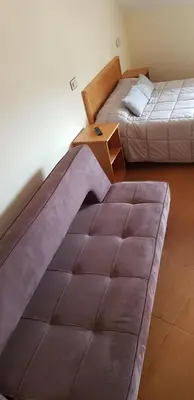 a room with two beds and a table in it at Hotel Alina in Cangas del Narcea