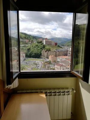 a window in a room with a view of a city at Hotel Alina in Cangas del Narcea