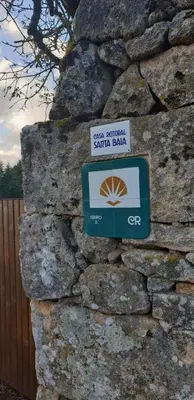 a sign on the side of a stone wall at Casa Rural Rectoral Santa Baia in Boimorto