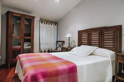 a bedroom with a bed with a colorful blanket on it at Casa da Labaceira in Santo Tomé