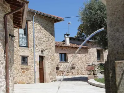 a building with a water hose in front of it at A Forxa - Casa Ferrador (Ribeira Sacra) in Sober