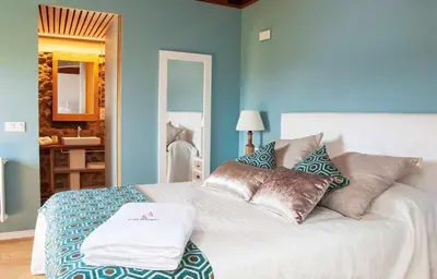 a blue bedroom with a bed with pillows on it at O Forno - Casa Ferrador (Ribeira Sacra) in Sober