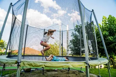 a girl jumping over a man on a trampoline at O Forno - Casa Ferrador (Ribeira Sacra) in Sober